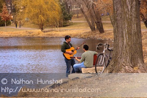 Two guitar players around Lake of the Isles.